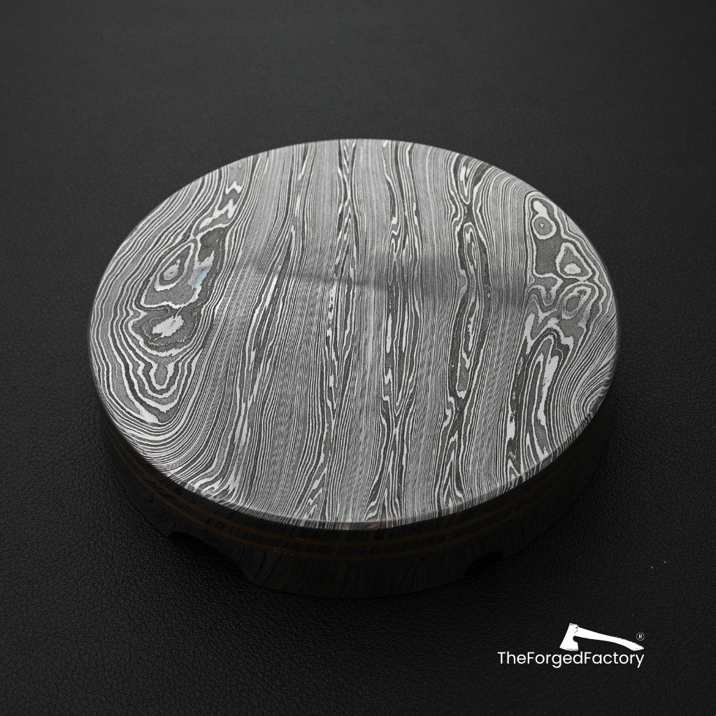 Metallic disc with intricate pattern on a black background, featuring 'The Forged Factory' logo.