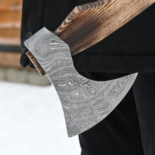 Decorative axe with a detailed blade and wooden handle on a blurred background