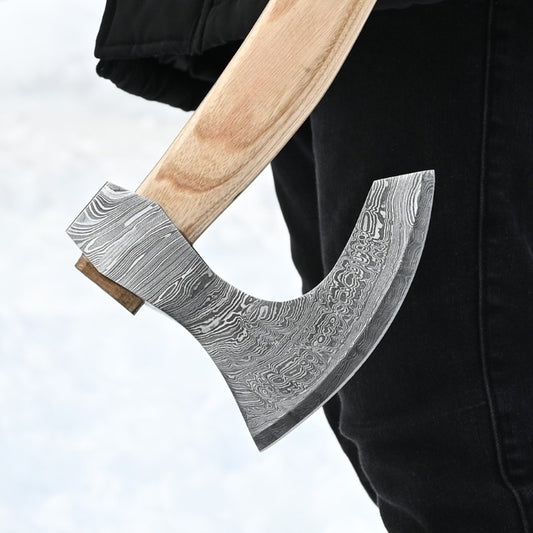 Decorative axe with a detailed blade held by a person against a light background