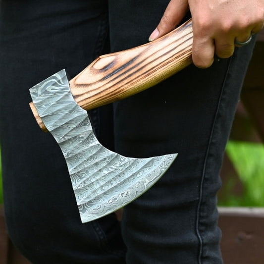 Person holding a decorative axe with a wooden handle