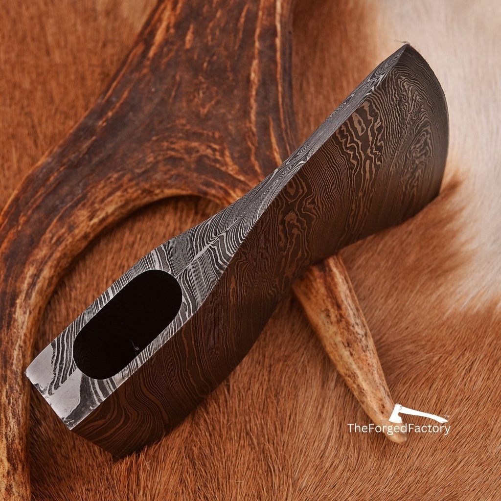 Damascus steel axe head with pre-shaped eye for DIY custom axe builds, black background.