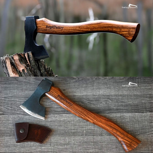 Wooden-handled axe with leather sheath on a wooden surface, branded 'Forged Factory'.