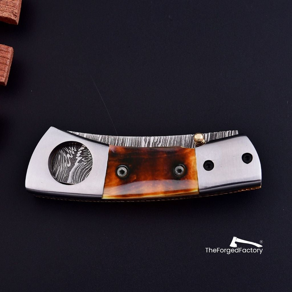 Cigar cutter Knife with bone handle on a black background, branded 'The Forged Factory'.