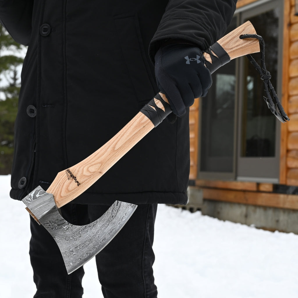 Person holding a large axe in a snowy outdoor setting