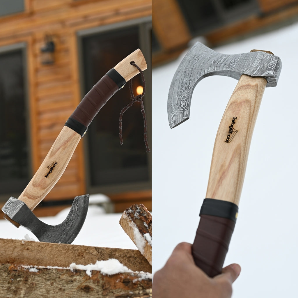 Two axes with wooden handles and metal blades, one being held by a hand.