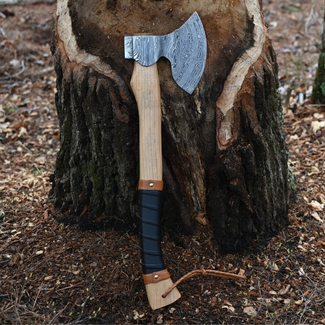 Outdoor camping Axe with wooden handle and metal blades on a tree stump in a forest setting