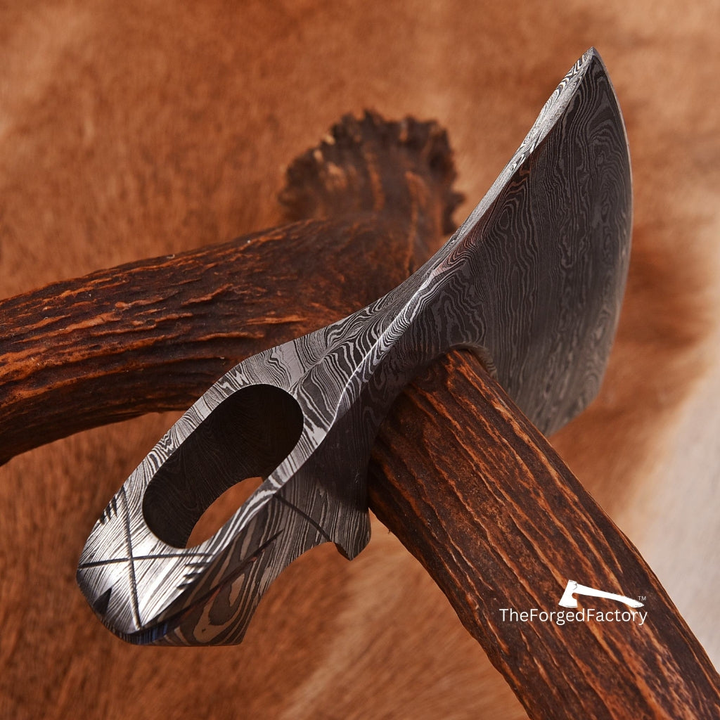 Decorative axe with a detailed metal head and wooden handle on a brown background, branded 'The Forged Factory'.