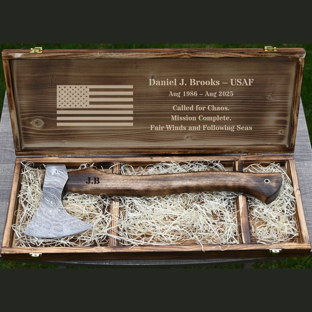Wooden box with engraved American flag and personalized text, containing a wooden functional outdoor camping axe.