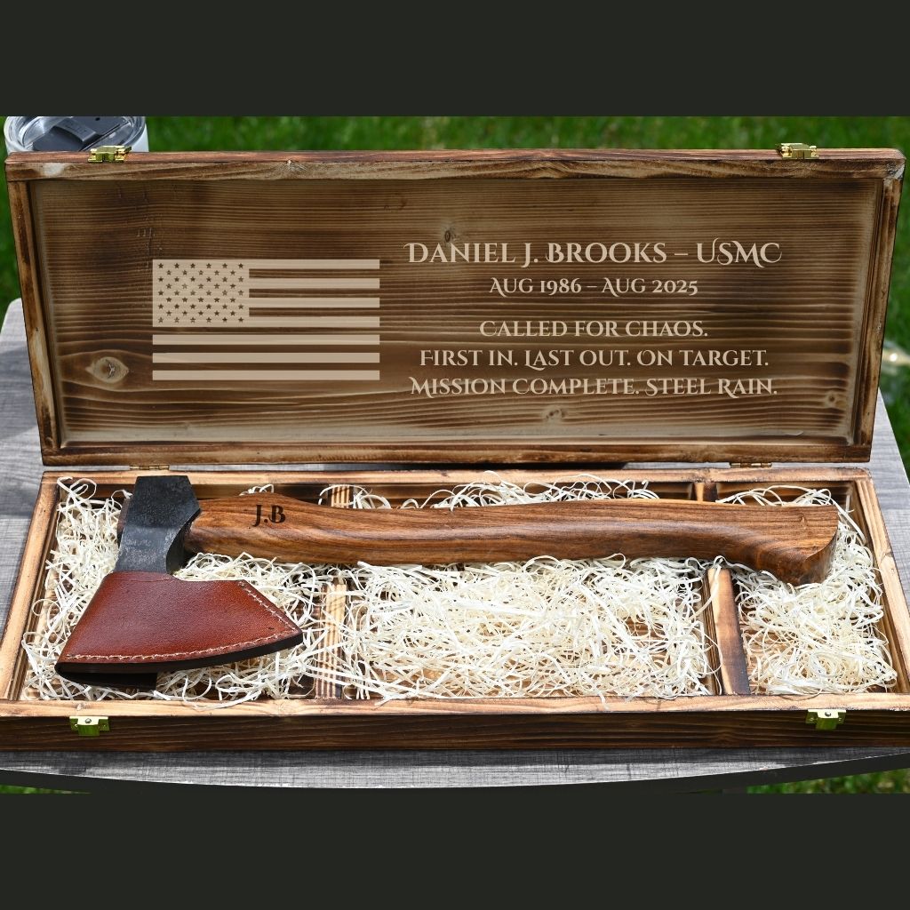 Wooden box with engraved text and American flag, containing a Functional camping outdoor axe with  leather sheath.