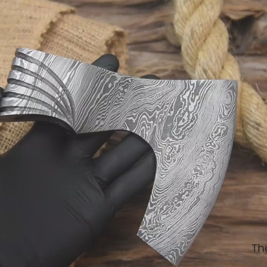 Functional Damascus axe head video showcasing layered steel patterns and artisan blacksmith craftsmanship.
