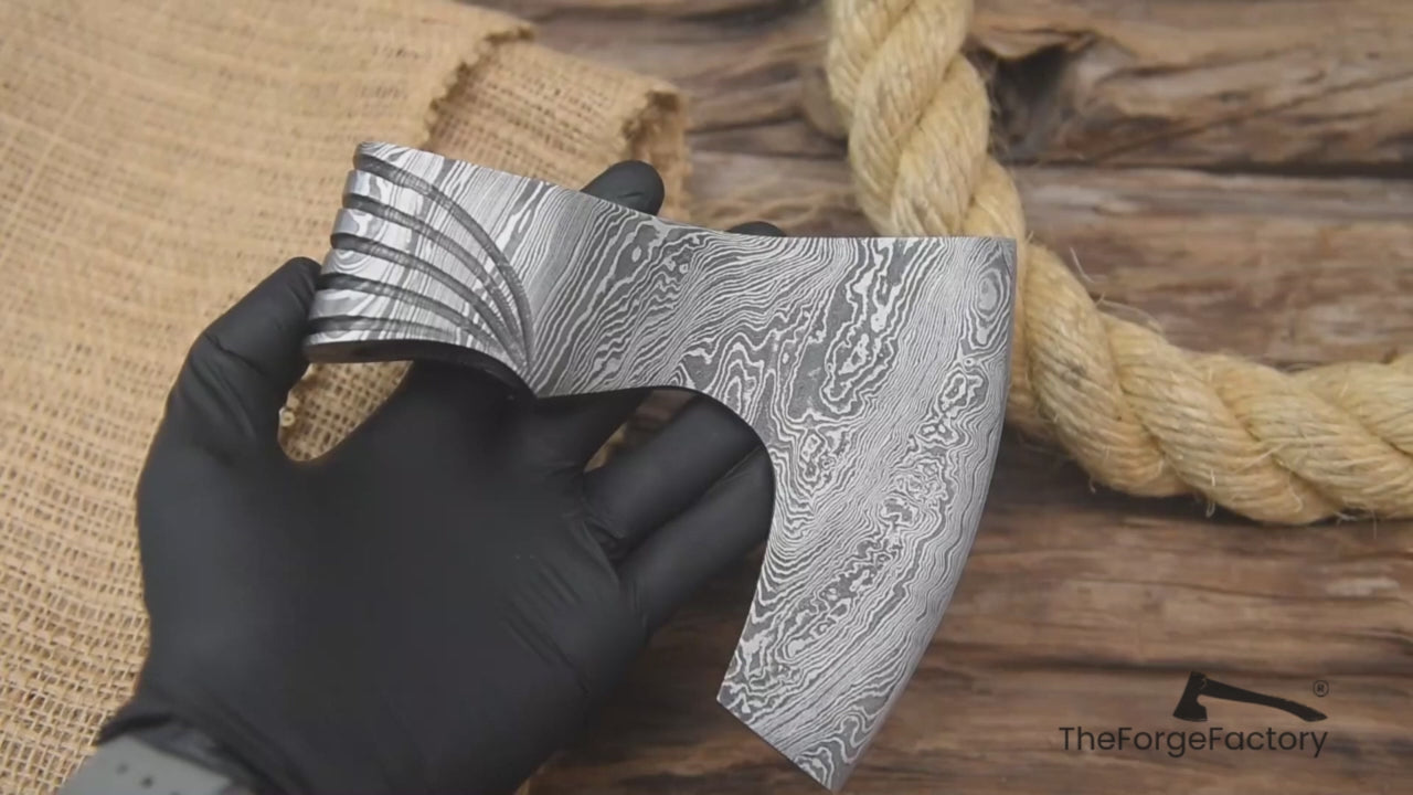 Functional Damascus axe head video showcasing layered steel patterns and artisan blacksmith craftsmanship.