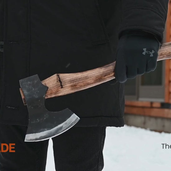 Multi-angle outdoor video of handmade carbon steel axe with ash handle, showcasing forged bushcraft hatchet craftsmanship in a winter setting.