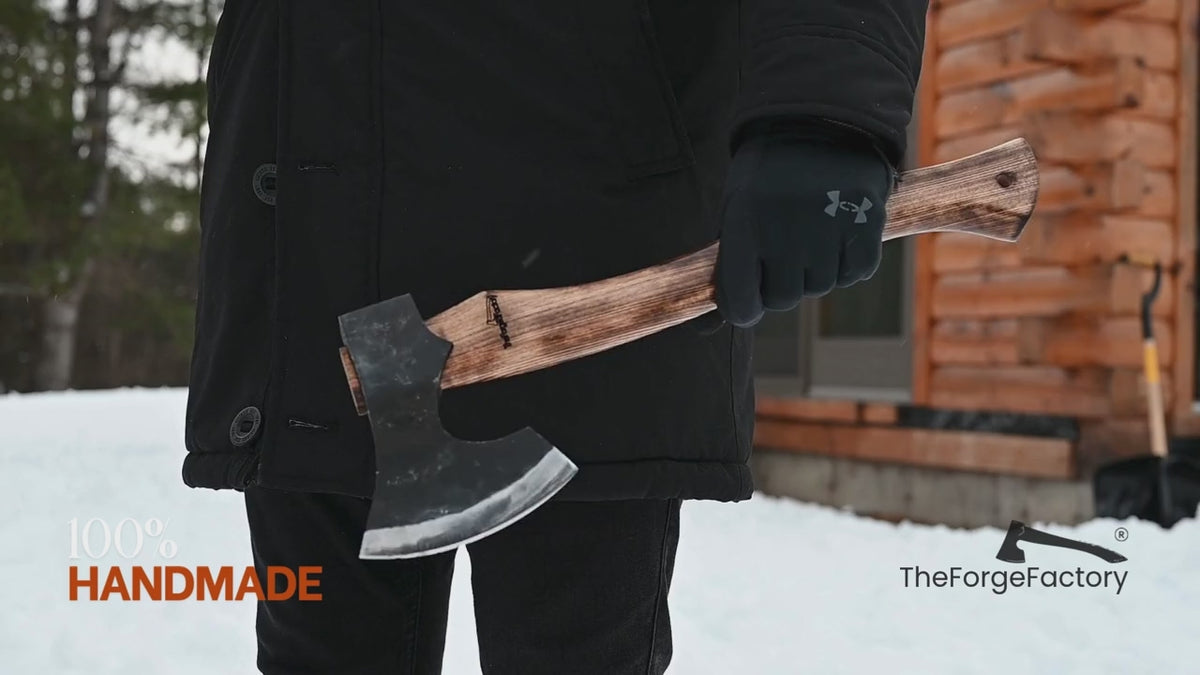 Multi-angle outdoor video of handmade carbon steel axe with ash handle, showcasing forged bushcraft hatchet craftsmanship in a winter setting.