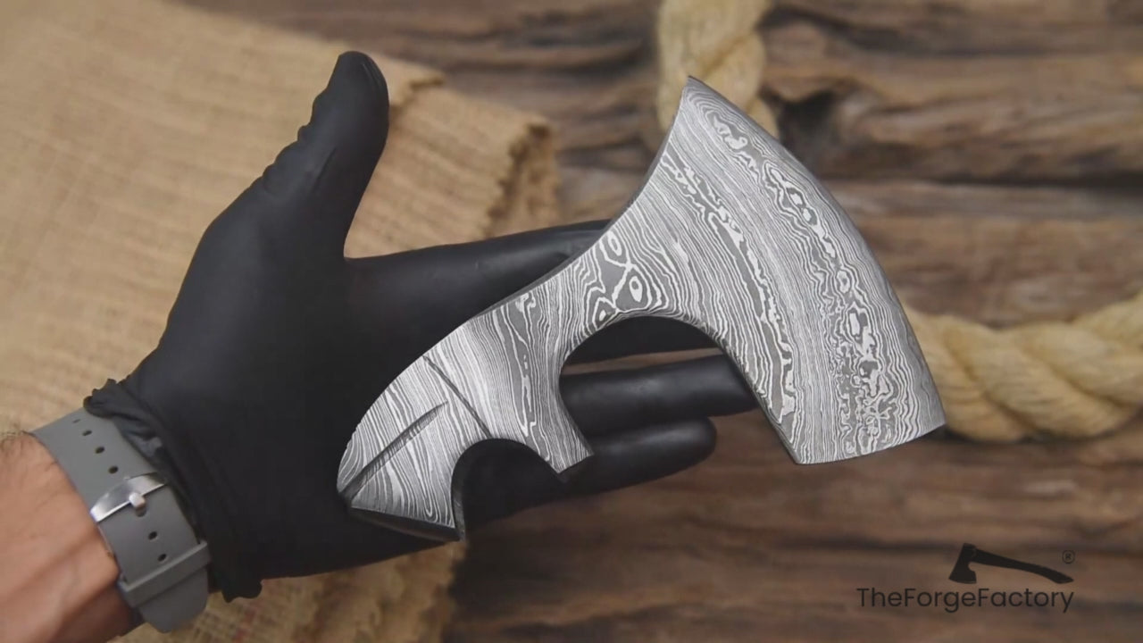 Rotating Damascus steel axe head video with “TheForgeFactory” branding for handmade camping and Bushcraft axes.