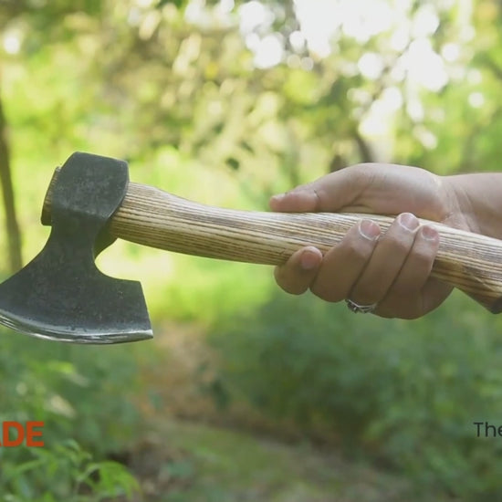 Multi-angle outdoor video of handmade bushcraft hatchet with wooden handle, showcasing forged axe craftsmanship in a forest setting.